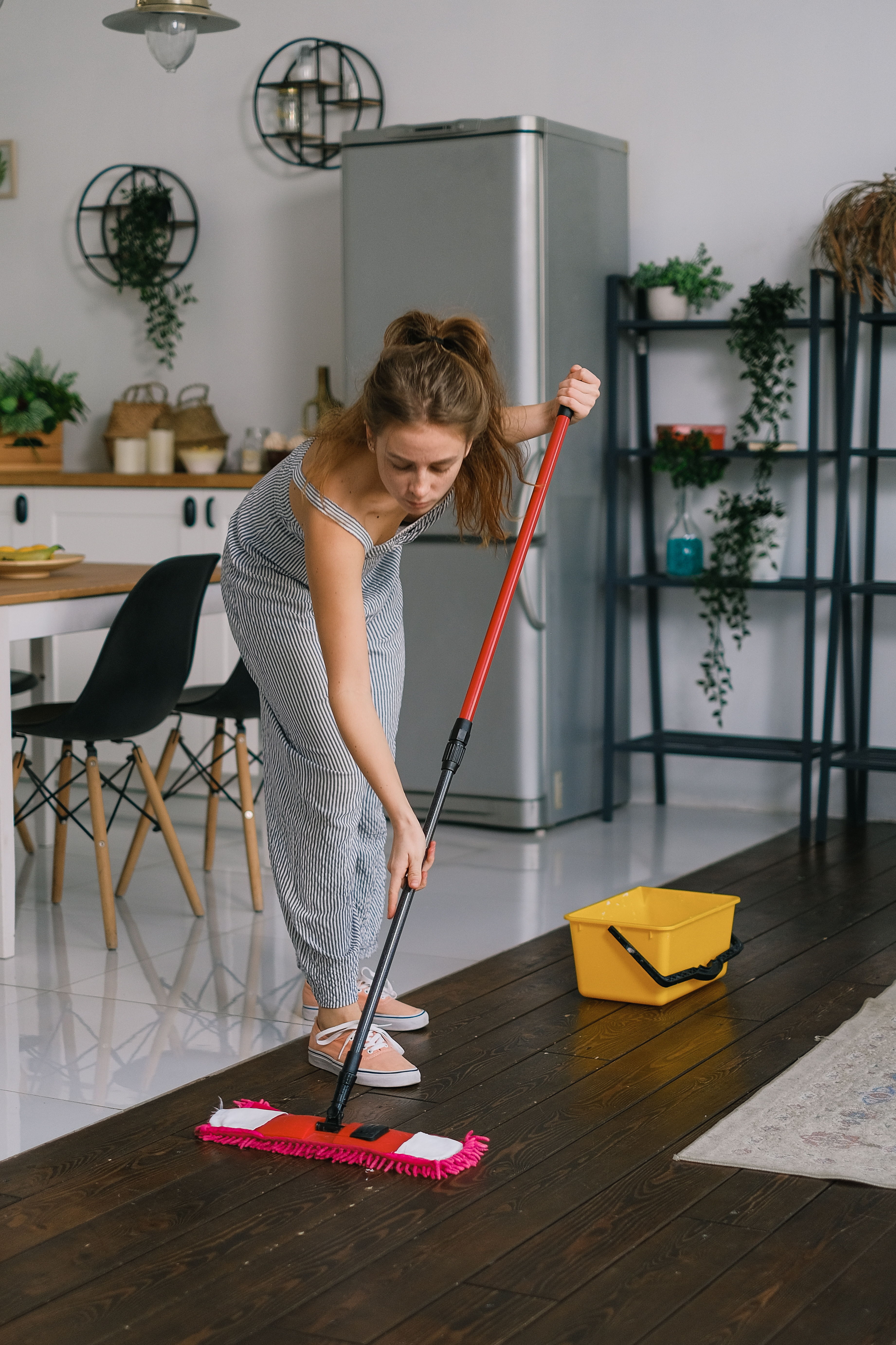 Homemaker Cleaning Floor with Mop in Room